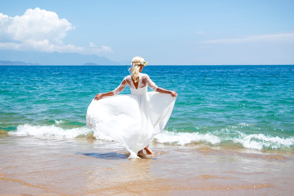 Bride standing before the tide.