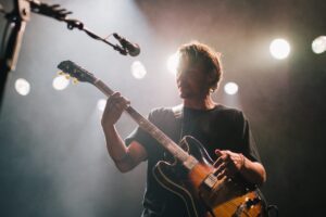Man playing guitar on stage.