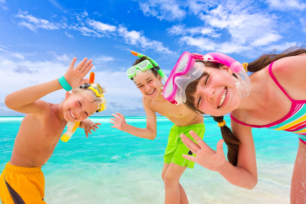 Kids smiling on beach: Myrtle Beach attractions for kids