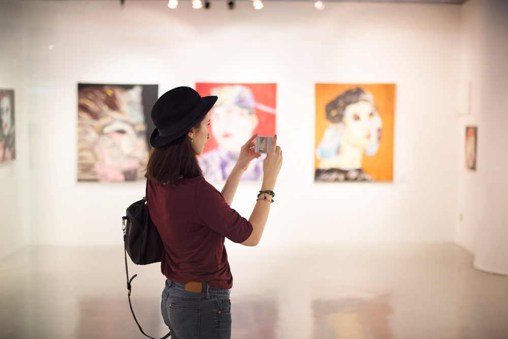 A woman takes a photo at a gallery/art museum in Myrtle Beach, SC, home of popular arts and culture scene.