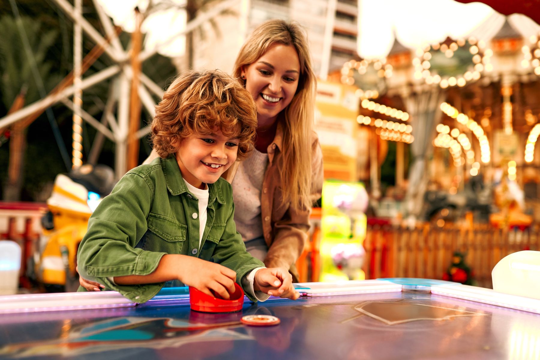 mom and son playing air hockey at festival